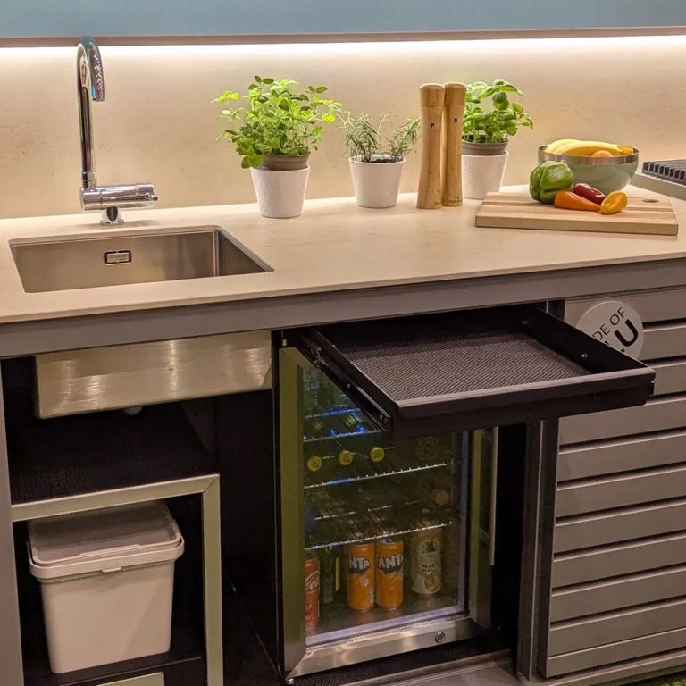 Drawer above fridge, narrow shelf, and pull-out bins in Dukin outdoor kitchen